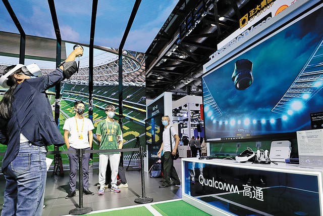 <p>A visitor (left) tries out GTVerse, a business-to-consumer mixed reality social network platform, at the China International Fair for Trade in Services in Beijing on 1 September 2022  </p>