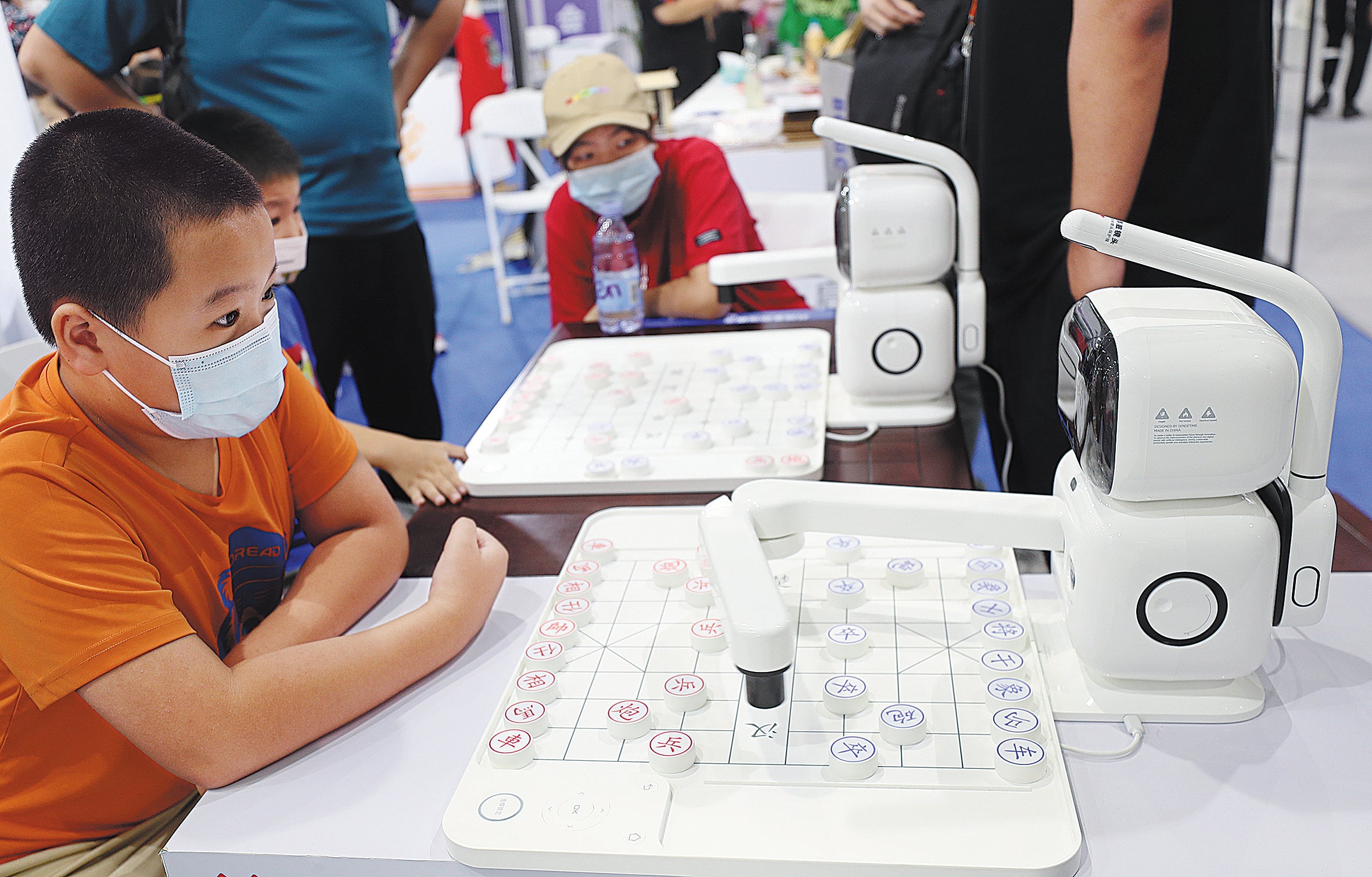 A boy plays Chinese chess with an artificial intelligence-featured robot at the China International Fair for Trade in Services in Beijing.