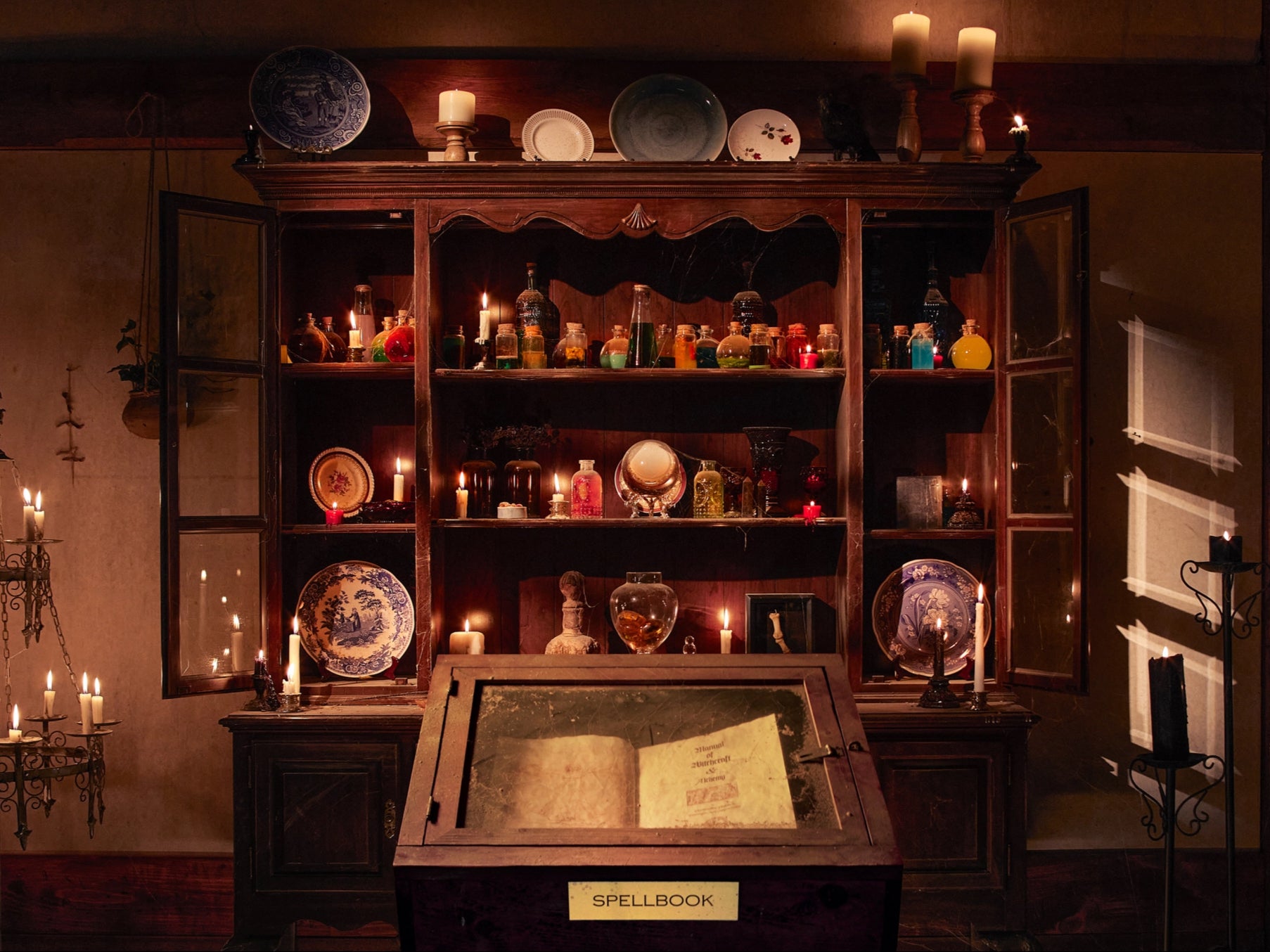 The ‘spellbook’ stands in front of a sideboard filled with bottles of potions