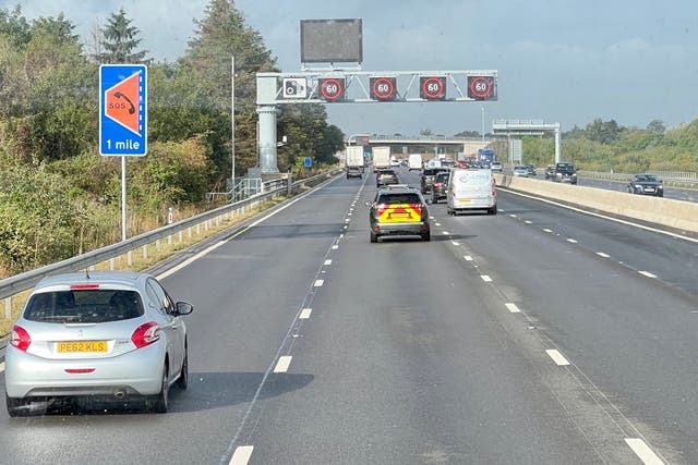 <p>All-lane running: a ‘smart’ section of the M4 motorway west from London, showing a sign for an emergency refuge and gantry with speed restrictions</p>