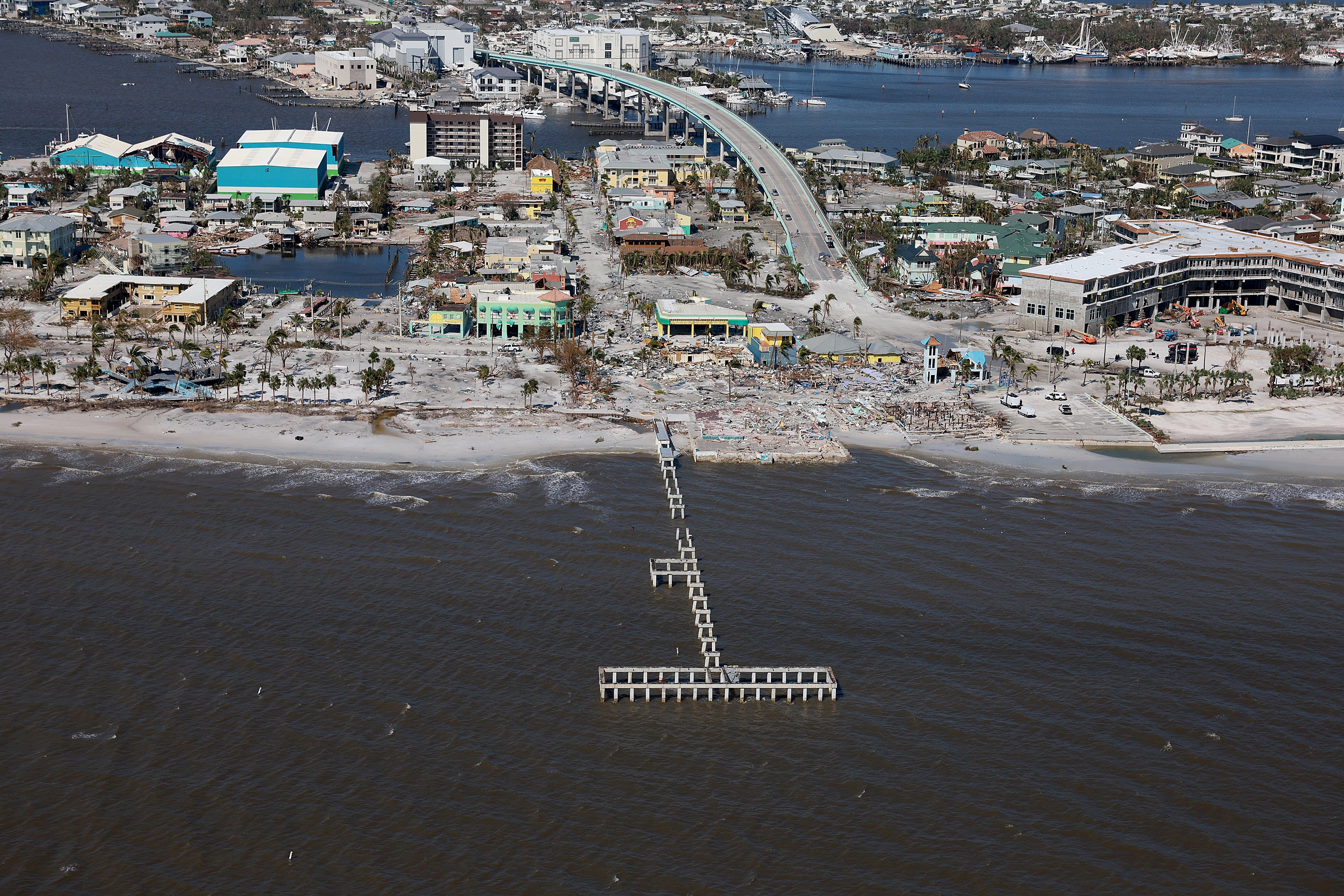 In an aerial view, a damaged Fort Myers Beach pier and surrounding buildings are seen after Hurricane Ian passed through the area on September 29, 2022 in Fort Myers Beach, Florida.