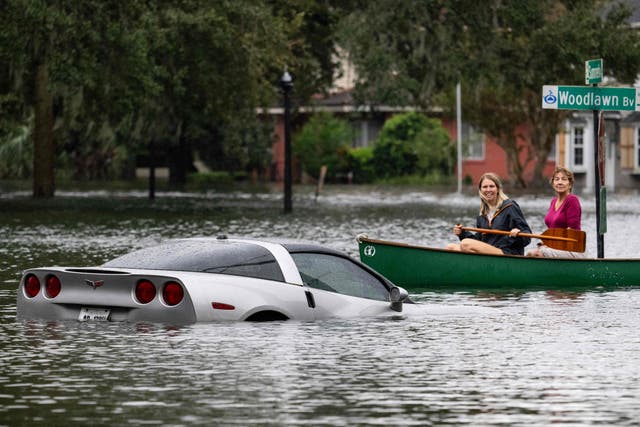 <p>People paddle by a submerged Chevy Corvette in the aftermath of Hurricane Ian in Orlando, Florida, on Thursday </p>