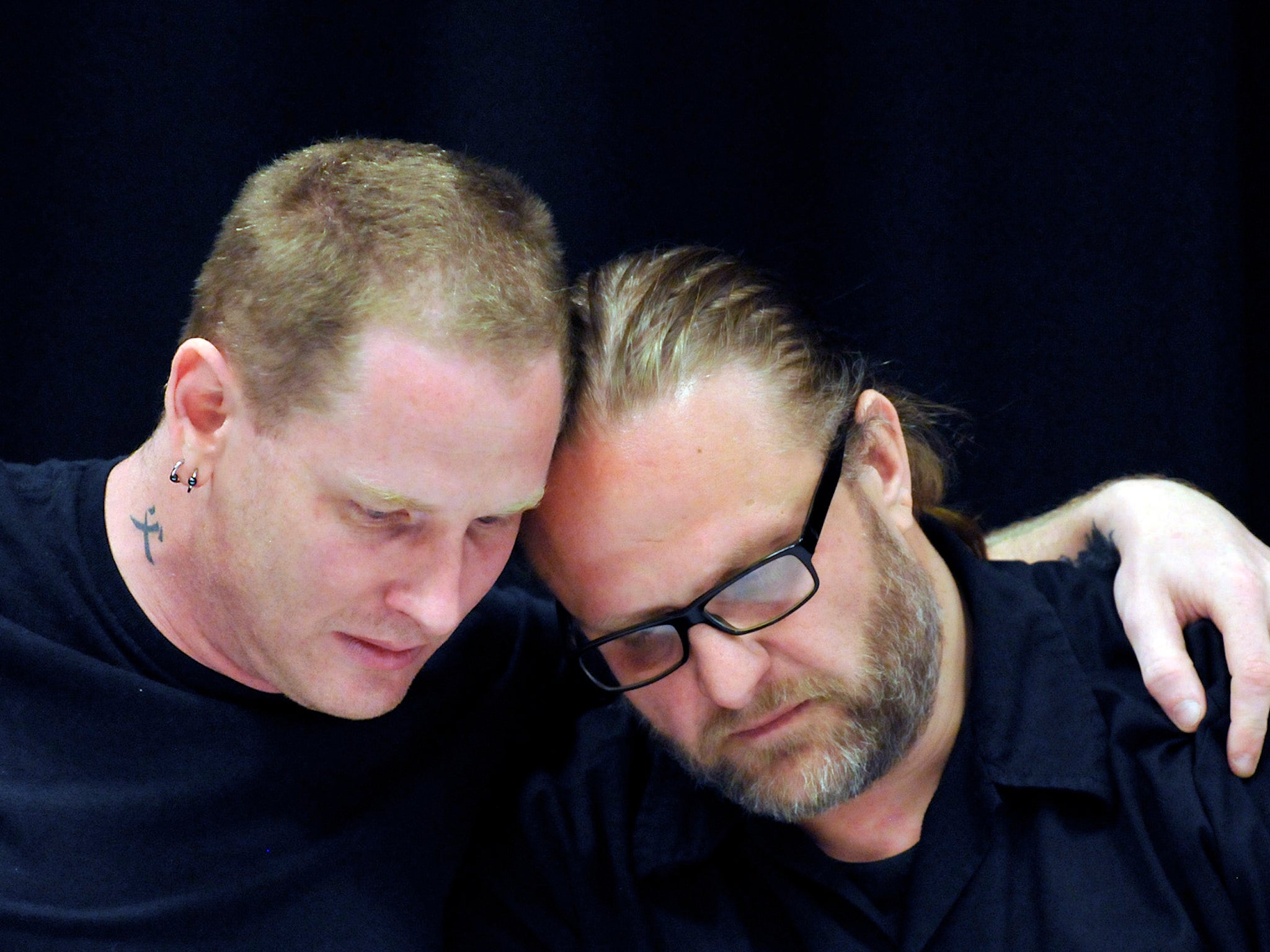 Slipknot vocalist Corey Taylor and Shawn Crahan console one another during a 2015 press conference addressing the death of bassist Paul Gray