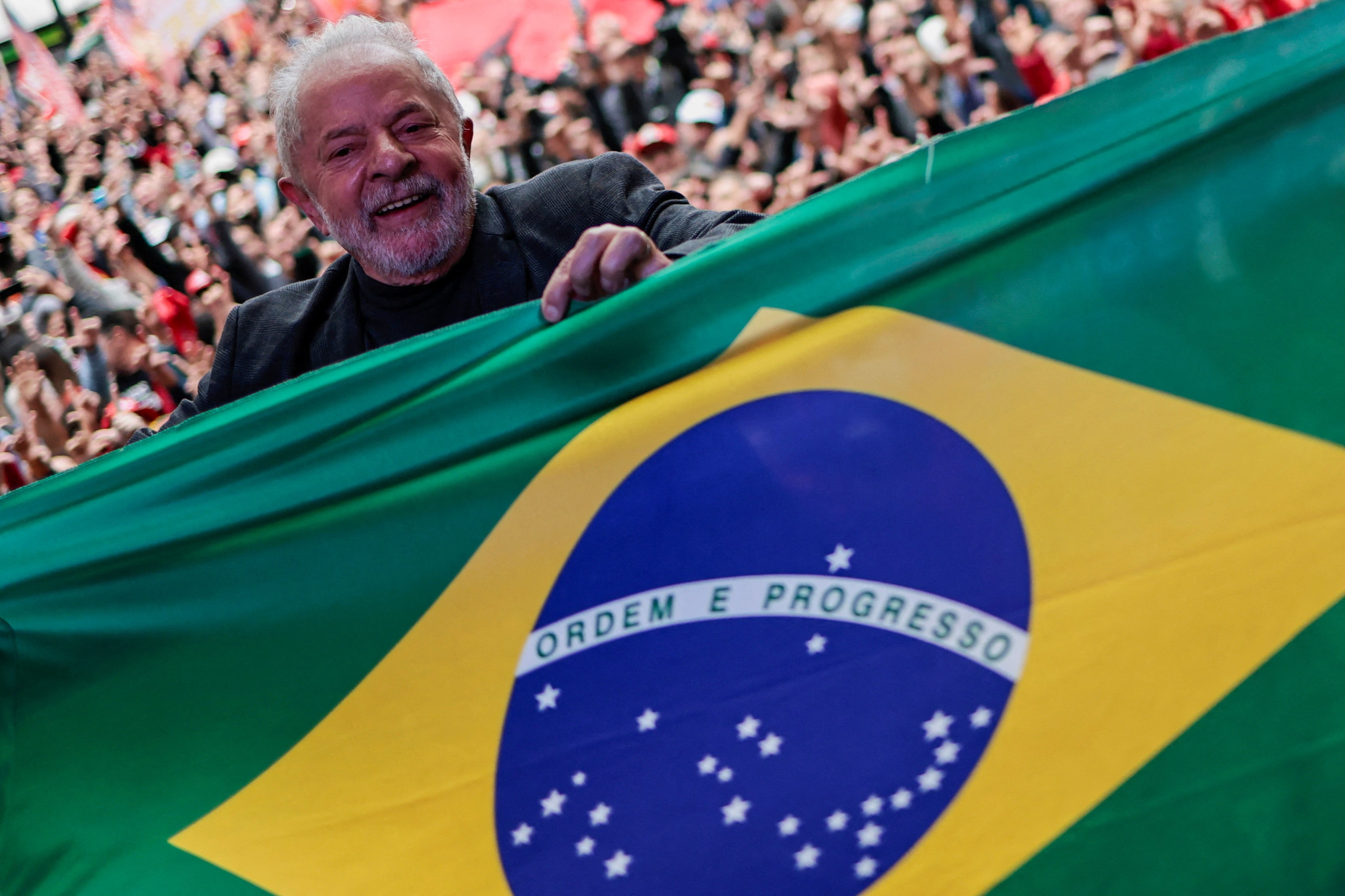 Lula holds a Brazilian flag on the campaign trail