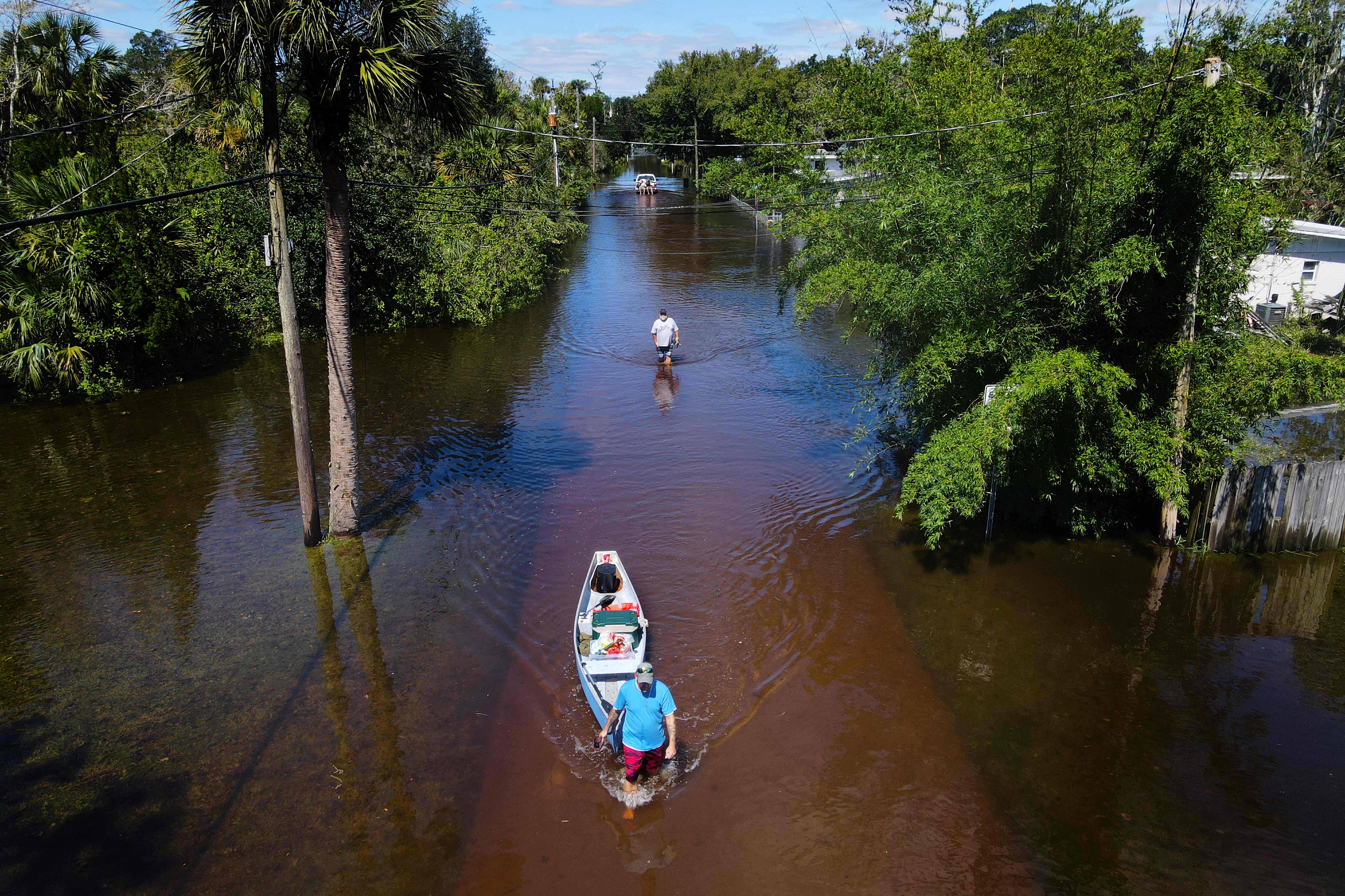 A man pulls a canoe through floodwaters in New Smyrna Beach, just north of Orlando