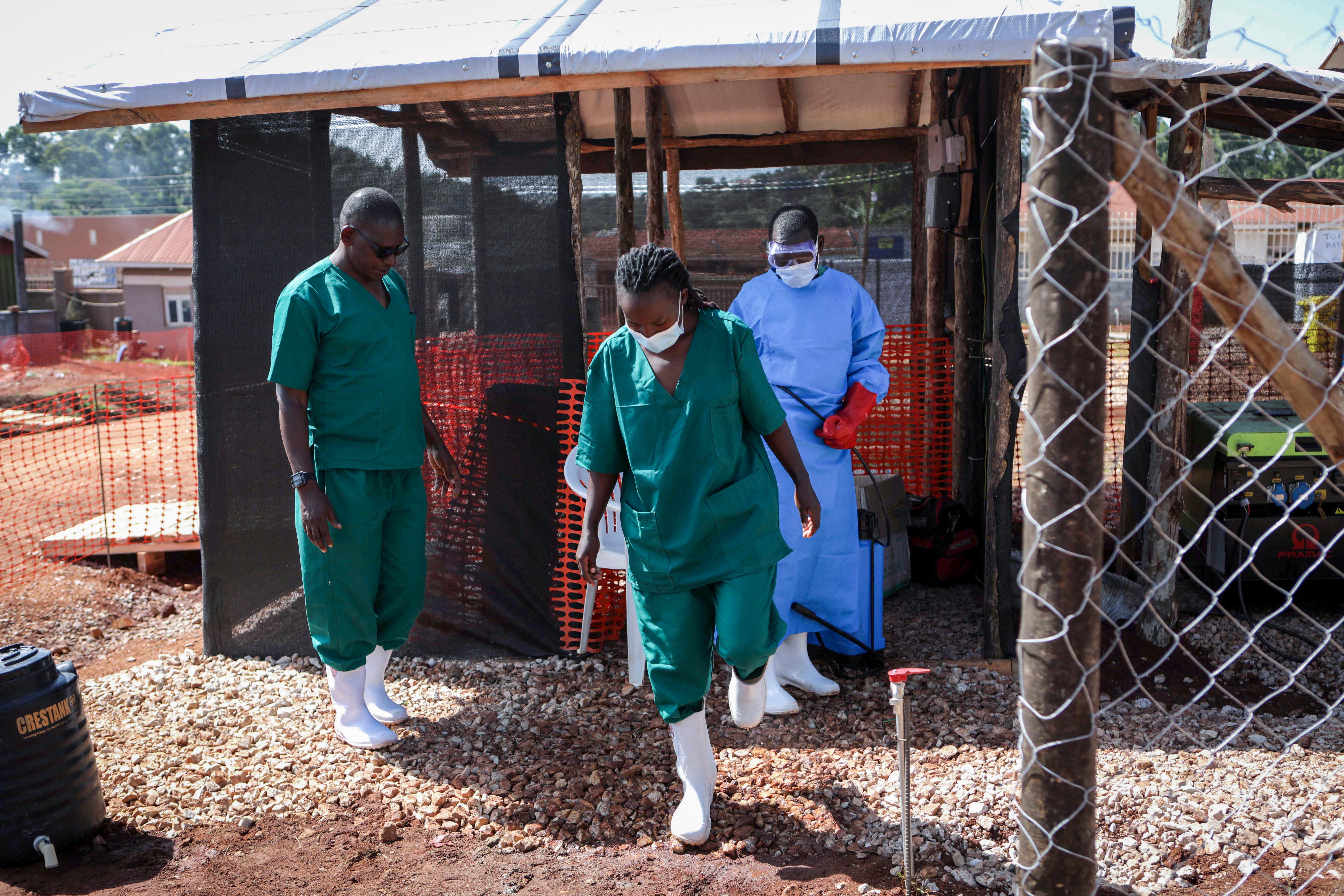 A medical attendant disinfects the rubber boots of a medical officer before leaving the Ebola isolation section of Mubende Regional Referral Hospital, in Mubende, Uganda