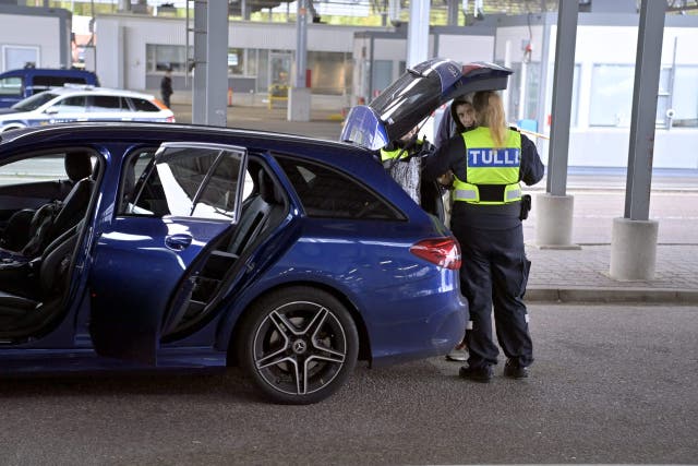 <p>Finnish customs officers talk to a man as they check a Russian vehicle at the Vaalimaa border checkpoint in Virolahti</p>