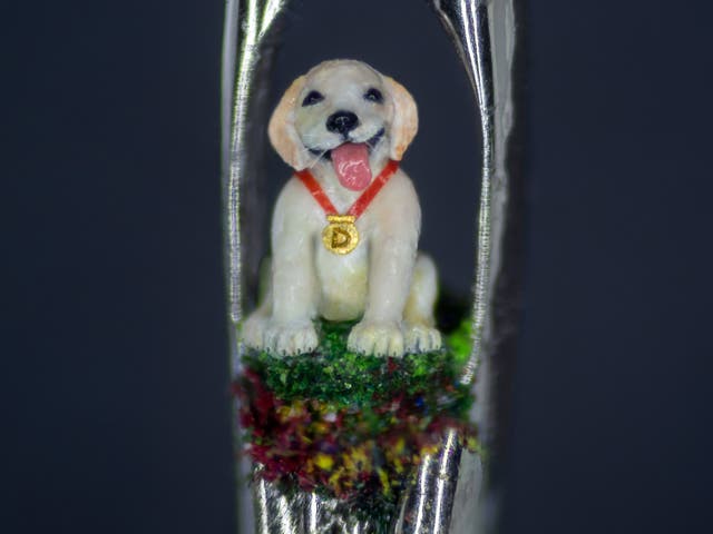 <p>Photo issued by the charity Guide Dogs of a micro sculpture of guide dog puppy Daniel, sitting in the eye of a needle, created by micro sculptor Willard Wigan </p>