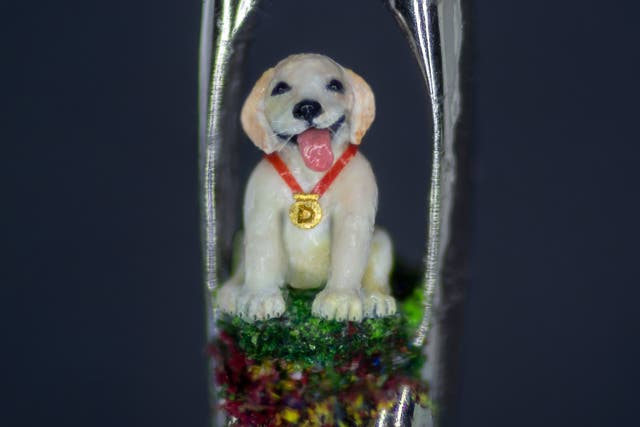 <p>Photo issued by the charity Guide Dogs of a micro sculpture of guide dog puppy Daniel, sitting in the eye of a needle, created by micro sculptor Willard Wigan </p>