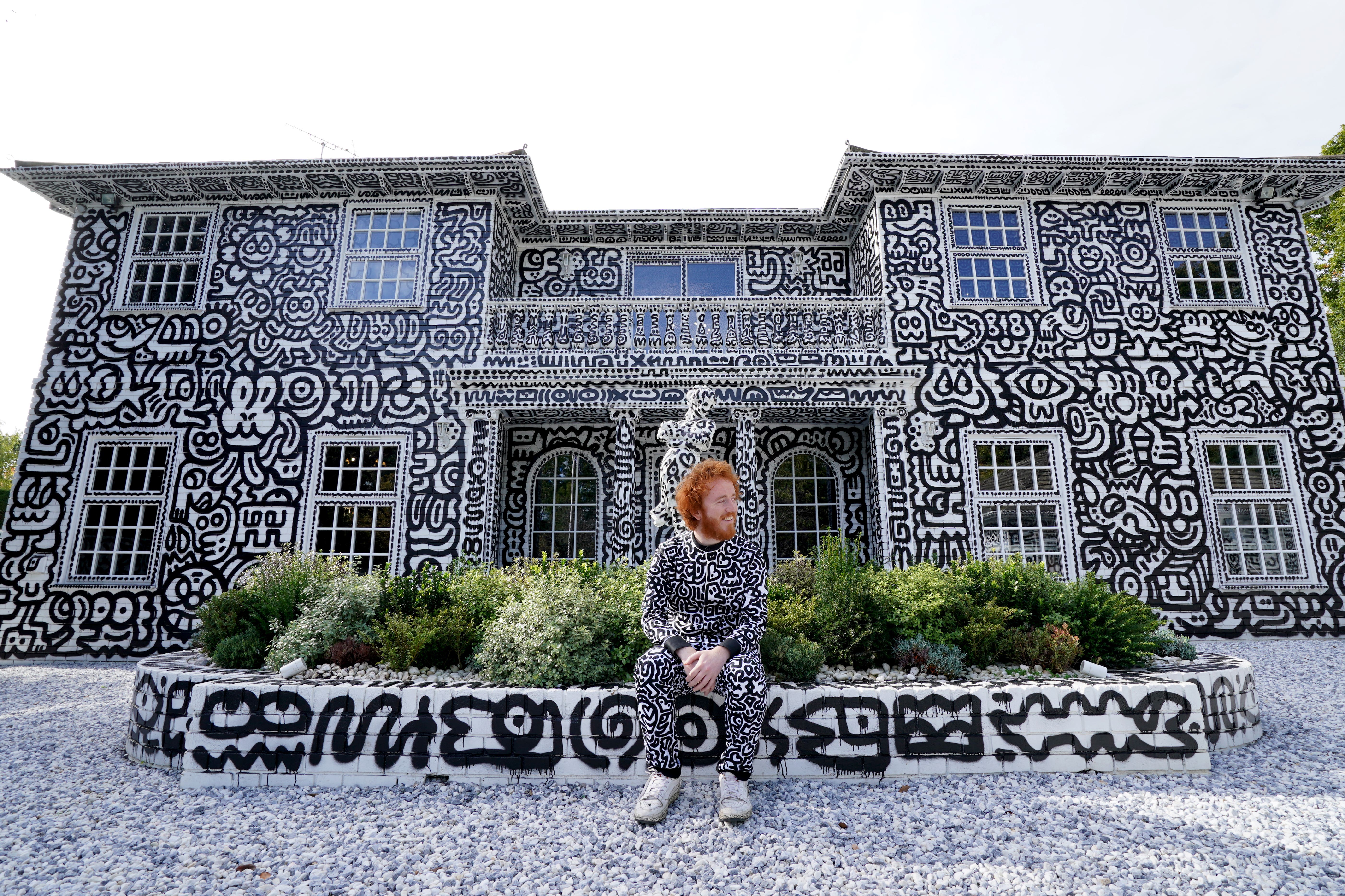 Sam Cox and his work at a 12-room mansion in Tenterden, which has been covered in the artist’s trademark monochrome doodles