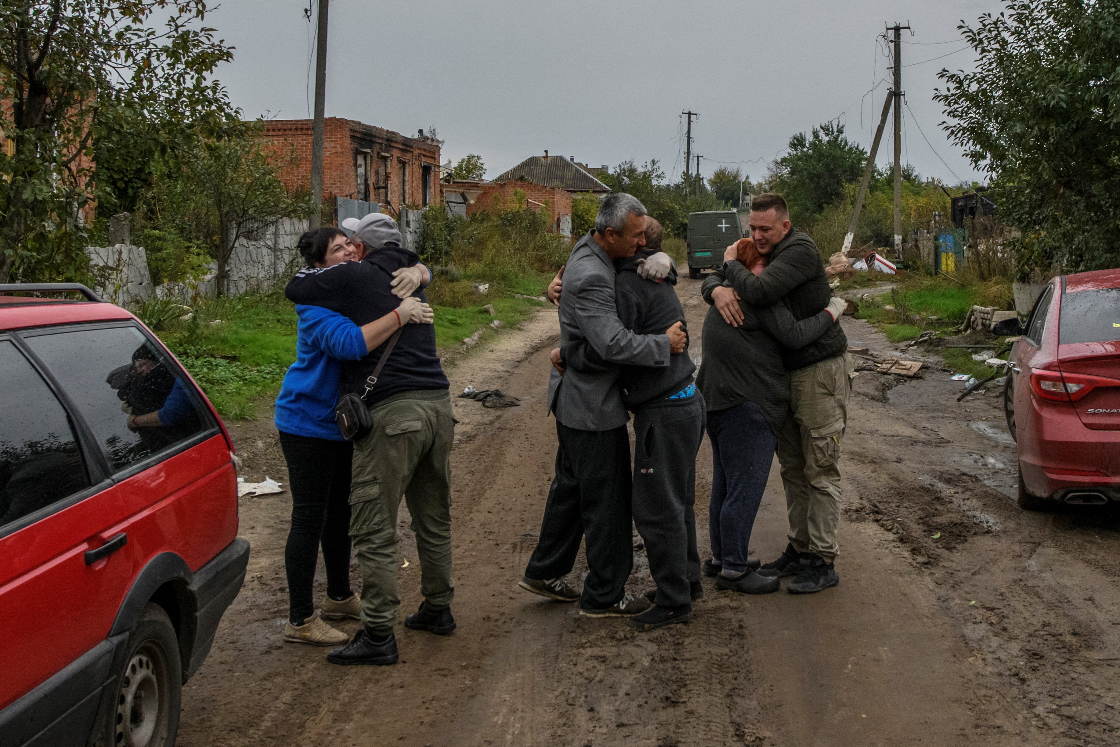 Neighbours embrace after they return from evacuation to the liberated village of Kamianka in the Kharkiv region on Sunday