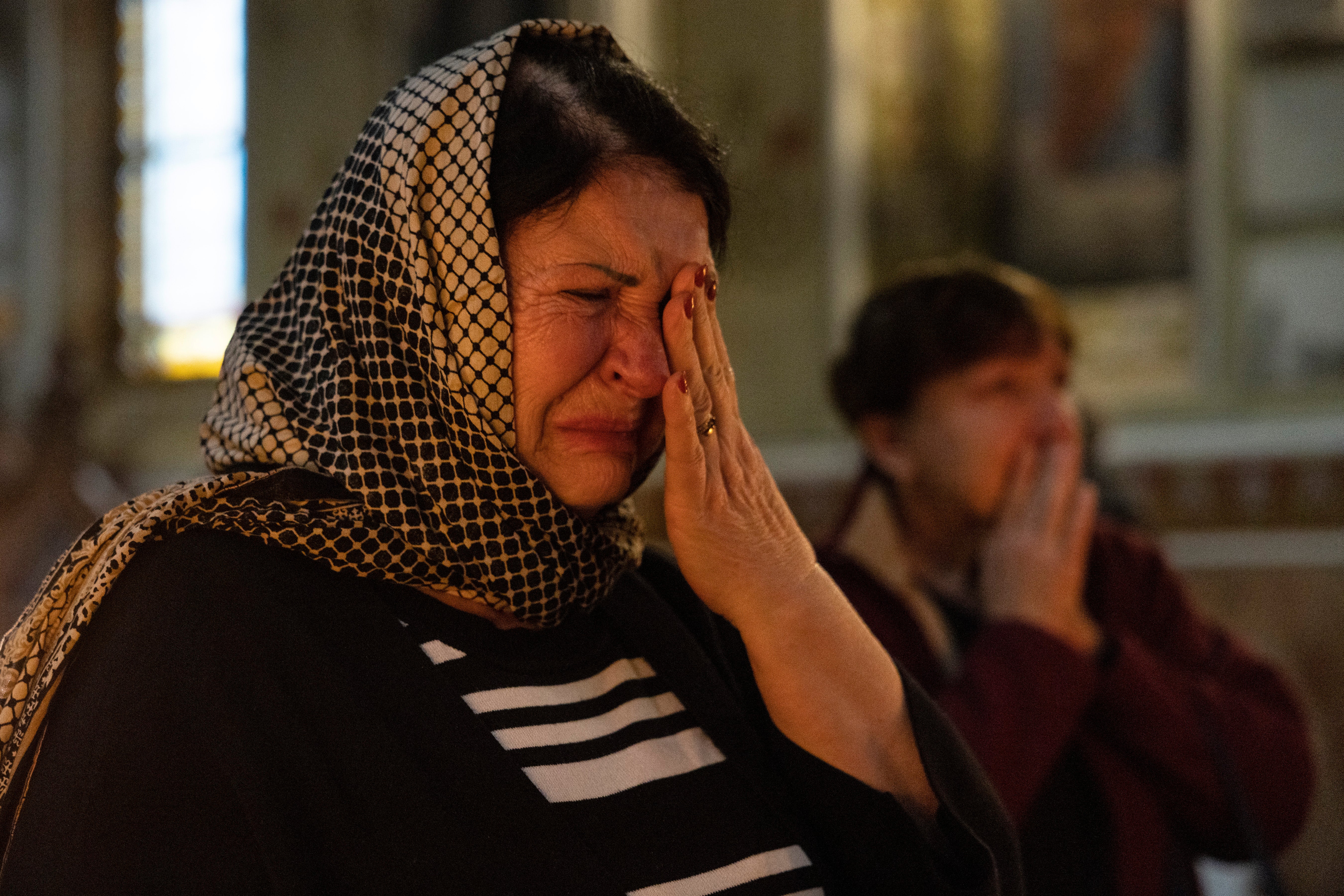 Tetiana cries as she prays during a Sunday afternoon service at the Pokrovsky cathedral in Kharkiv