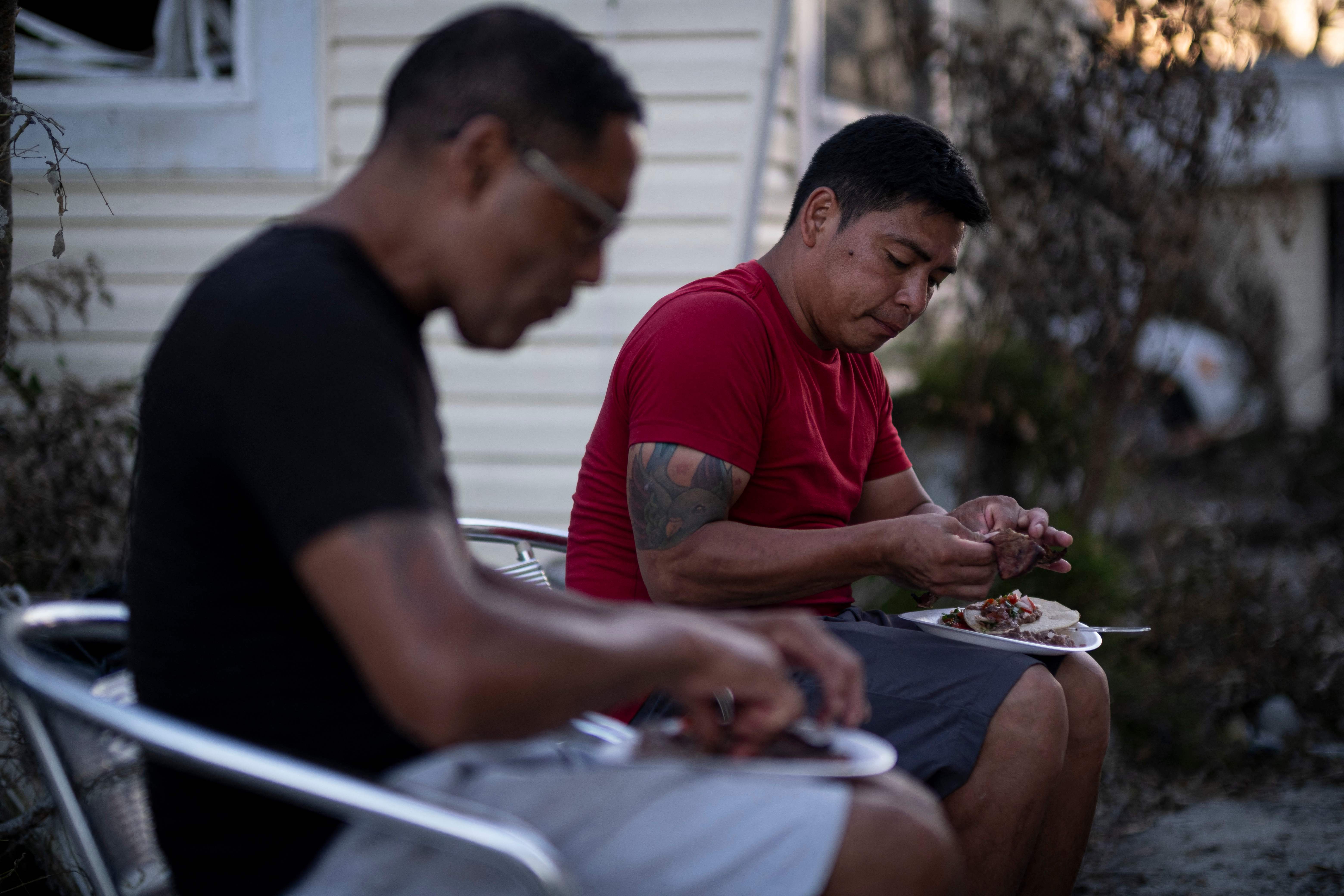 Two people eat dinner in Fort Myers Beach on Sunday as the area recovers from Hurricane Ian