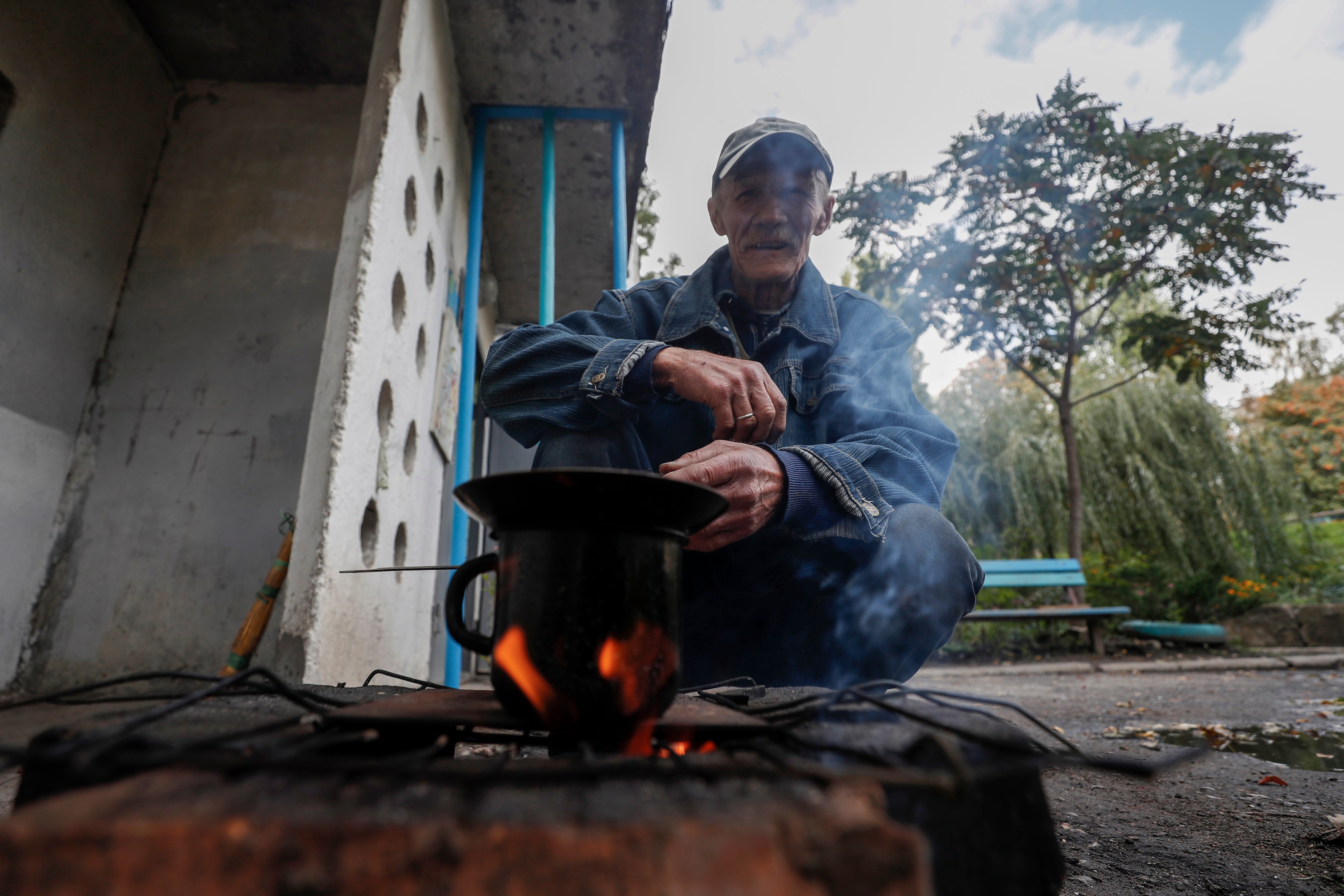 Batslava, an elderly Ukrainian, preparing soup on a stove in the newly liberated city of Kupyansk, east of Kharkiv, on Monday