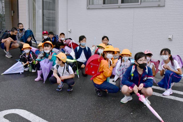 <p>Elementary school students in Misawa, northern Japan, find shelter near a building on their way to school after North Korea’s missile launch </p>