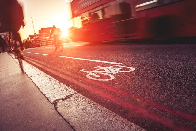 <p>A cyclist in a bike lane in London, Westminster Bridge at dusk (stock image) </p>