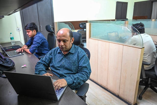 <p>Pratik Sinha (C), the co-founder of AltNews works on a laptop in his office in Kolkata</p>