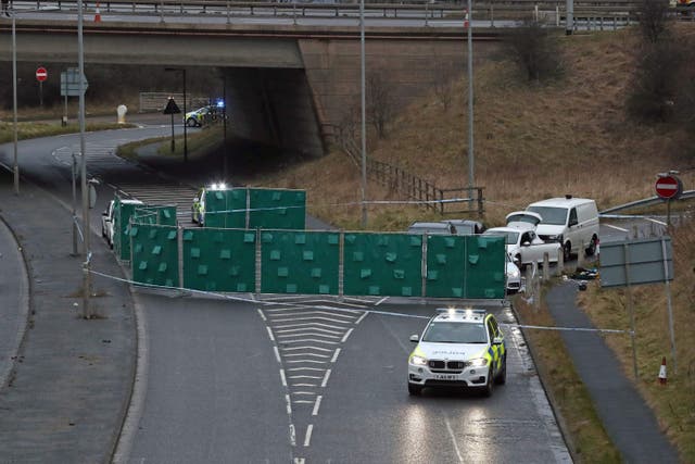 A silver Audi is almost totally hidden by screens at the scene near junction J24 of the M62 in Huddersfield where a man died in a police shooting during a ‘pre-planned’ operation (Peter Byrne/PA)