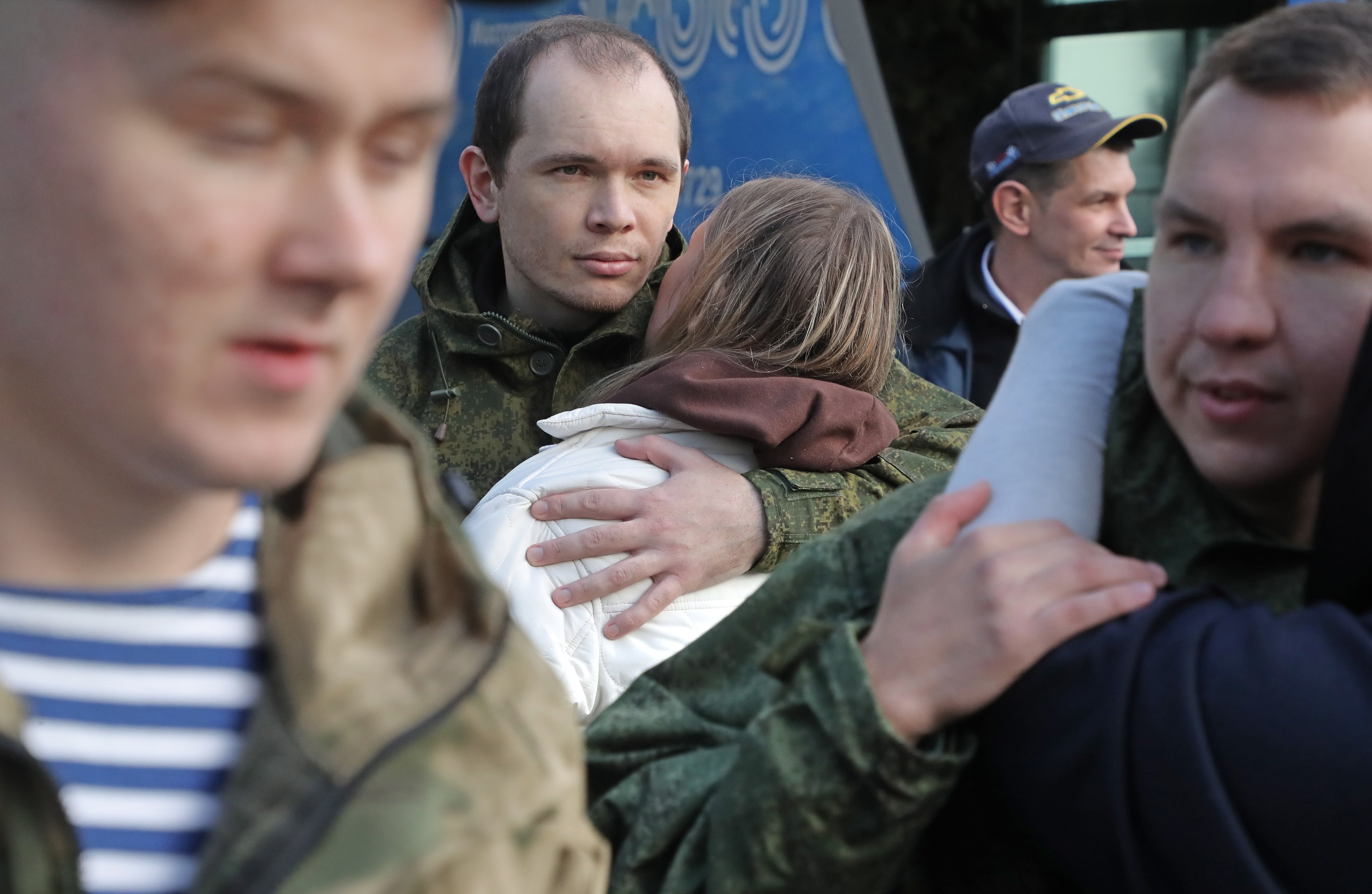 Russian conscripted men say goodbye to relatives at a recruiting office