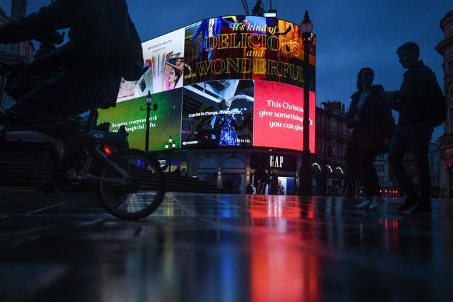 <p>A Christmas themed billboard illuminates Piccadilly Circus on 21 December 2020 in London</p>