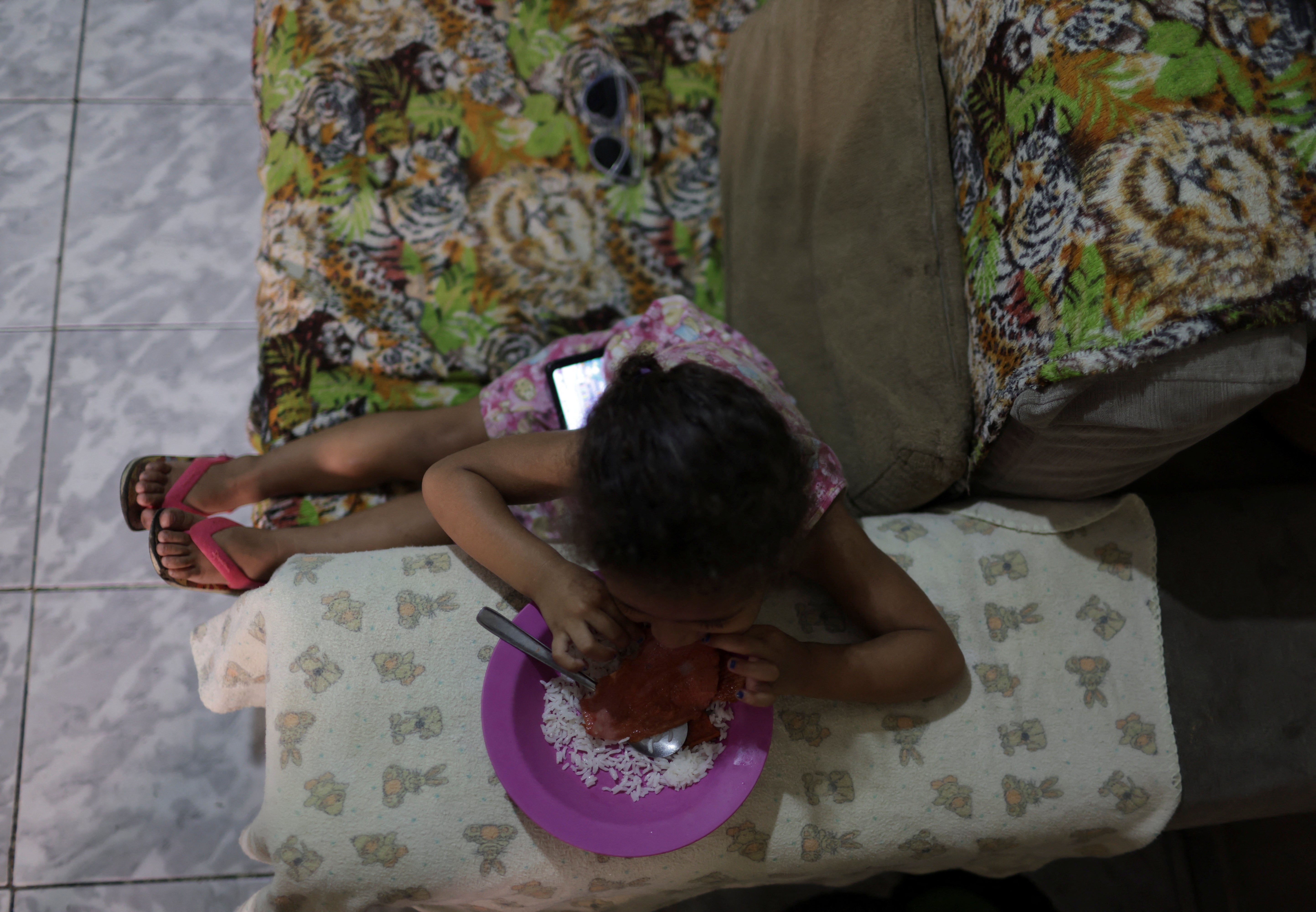 Izabela, 2, eats a meal made from food found in a garbage container by her mother Carla