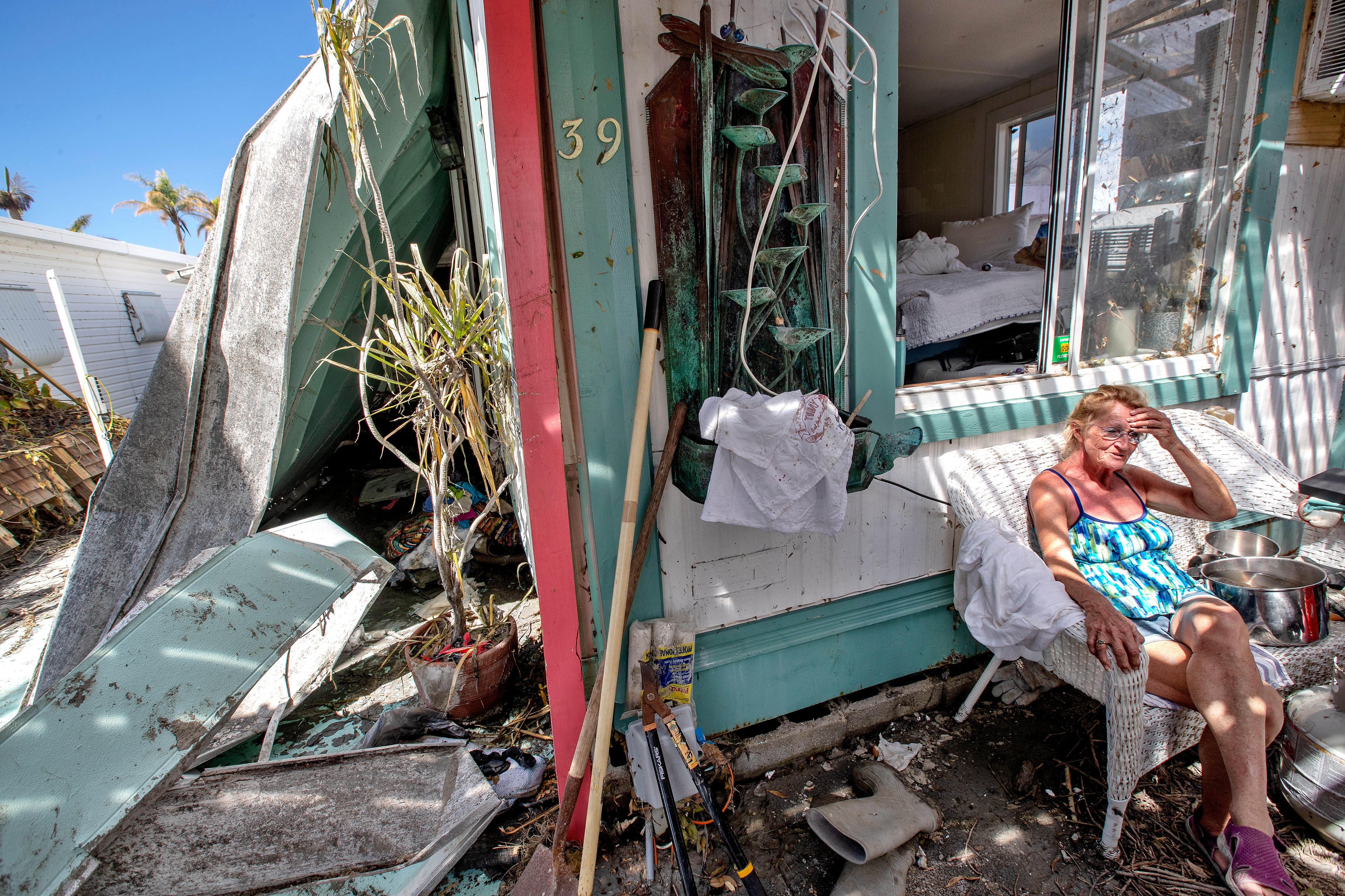 A woman sits outside her damaged home in Fort Myers Beach, Florida on Wednesday