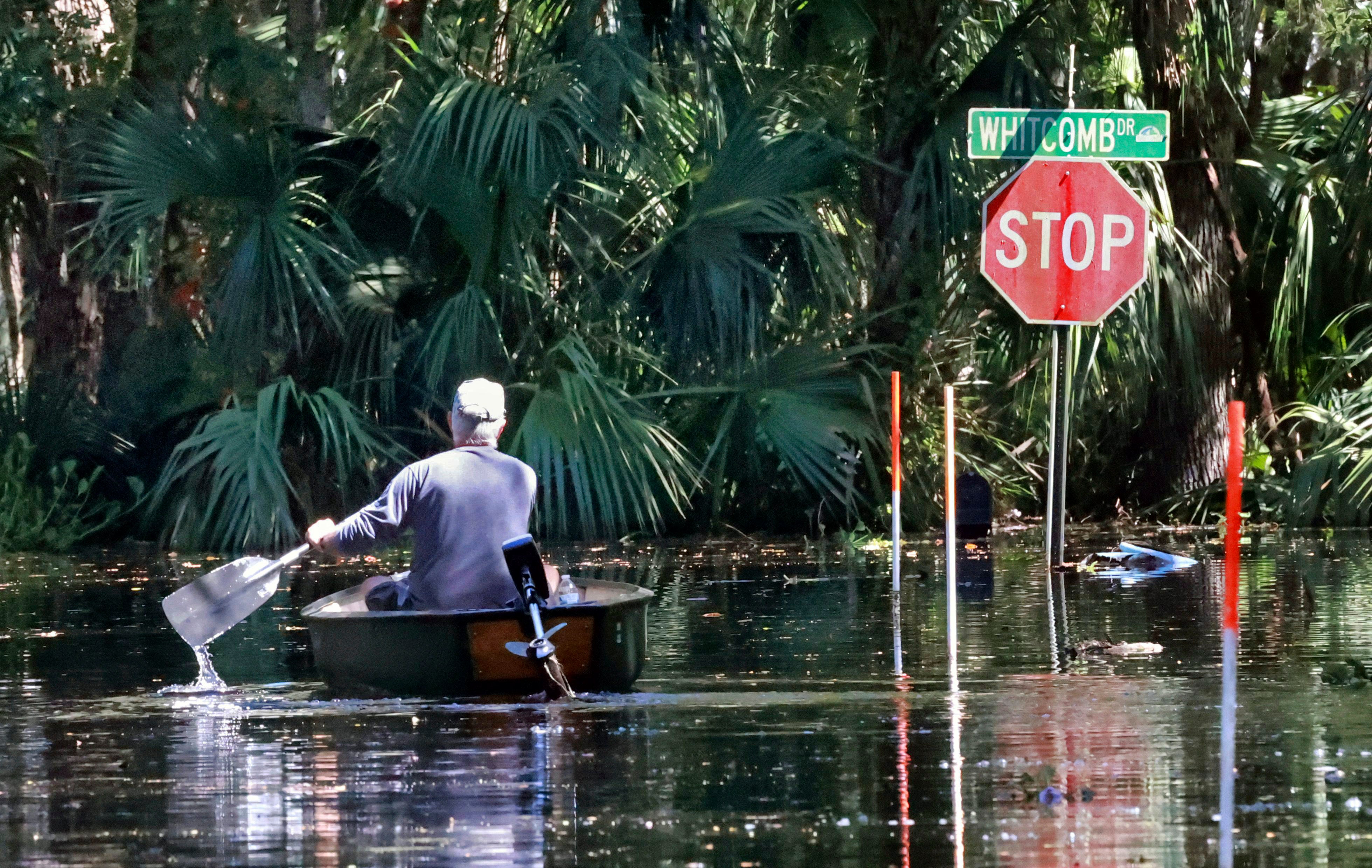 <p>A man canoes through his neighbourhodd in Geneva, Florida, which is still flooded more than a week after Hurricane Ian</p>
