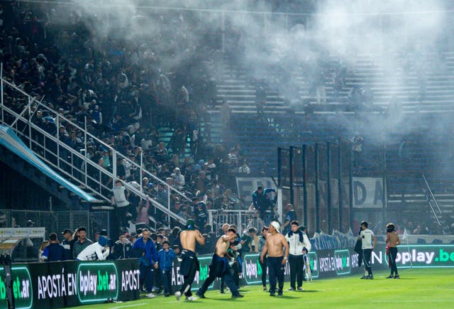 <p>Fans at the Juan Carmelo Zerillo Stadium were forced on to the pitch after tear gas drifted in to the stands </p>