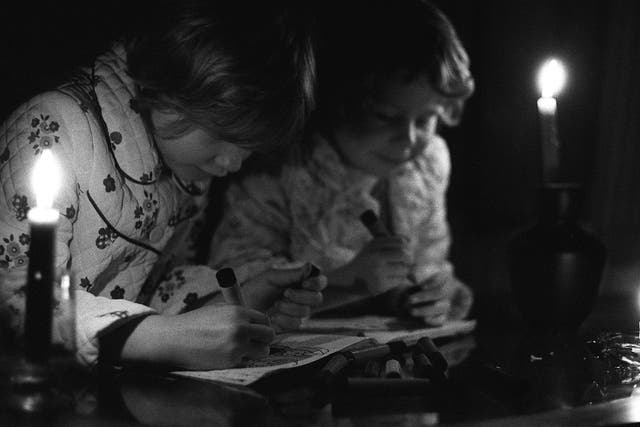 <p>Colouring by candlelight for Tracy Caulkin, seven, and her sister Jaqui, five, in 1977 as the nation faced another round of blackouts  </p>