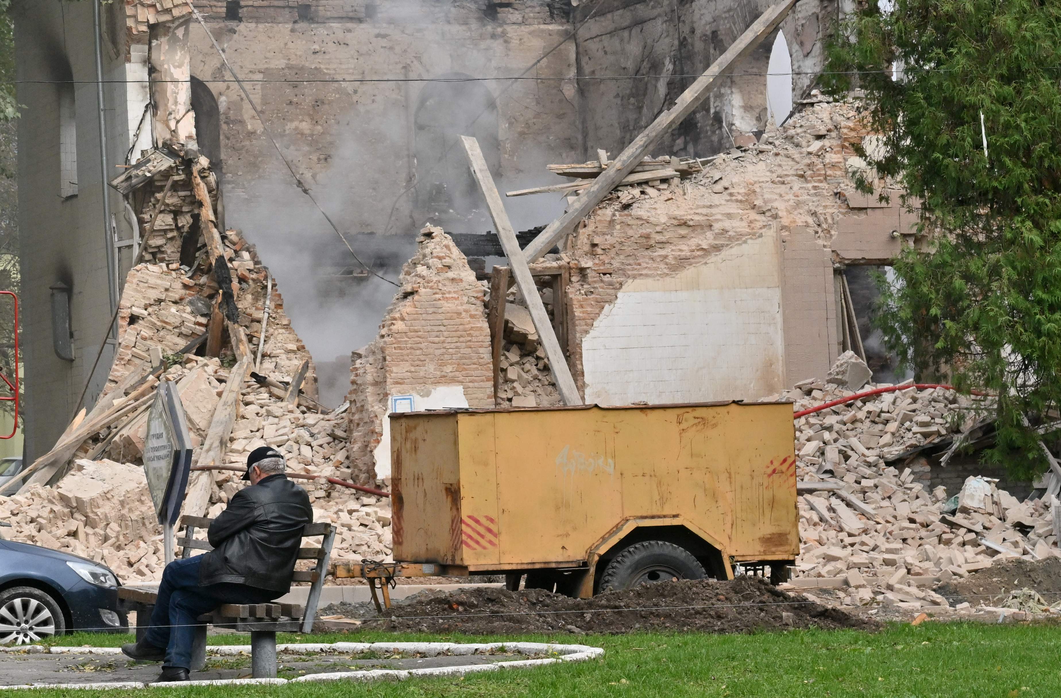 A local resident sits outside a building destroyed by Russian, Iranian-made, drones after an airstrike on Bila Tserkva, southwest of Kyiv