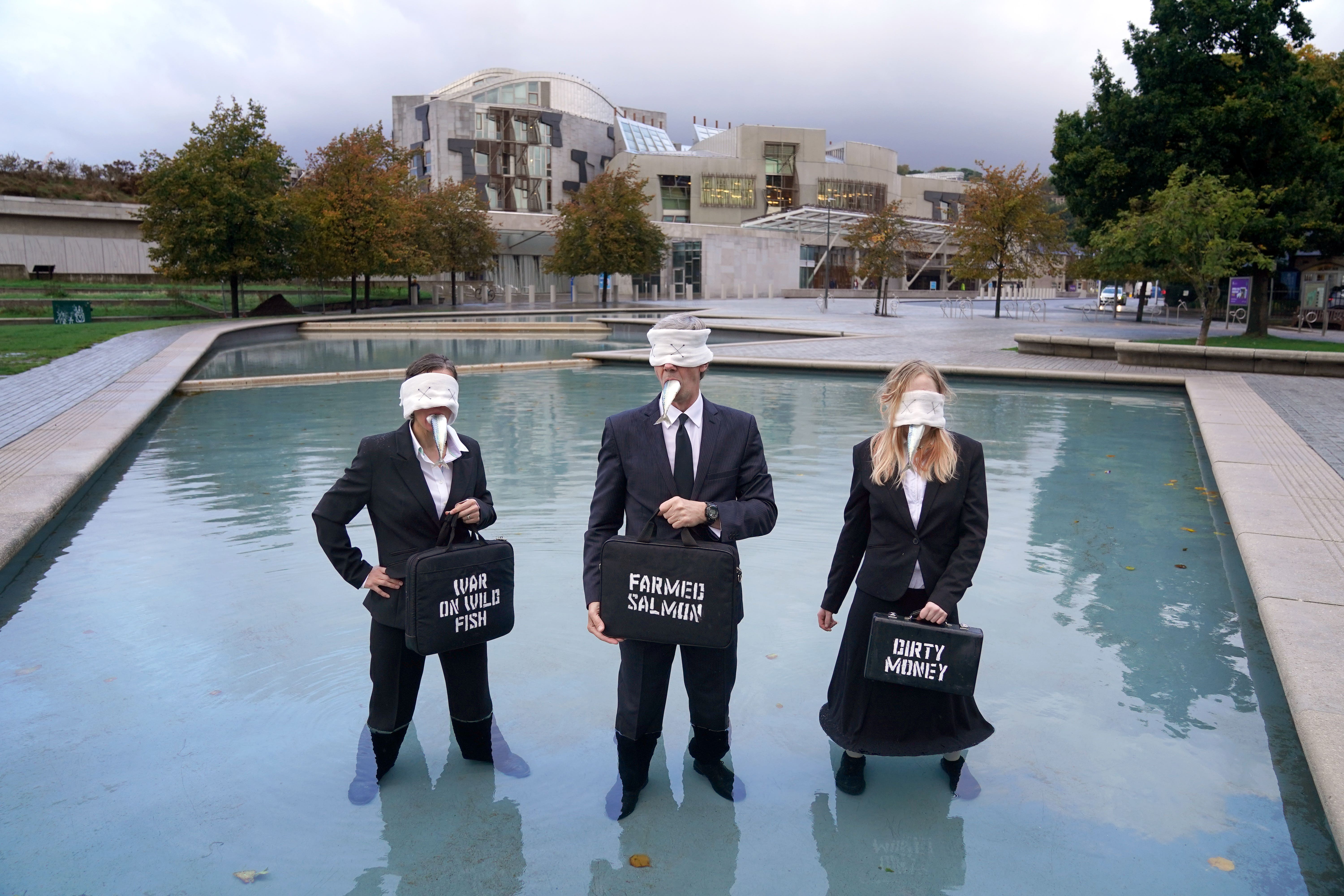 Suited performers from Ocean Rebellion stage a stunt outside Holyrood (Andrew Milligan/PA)