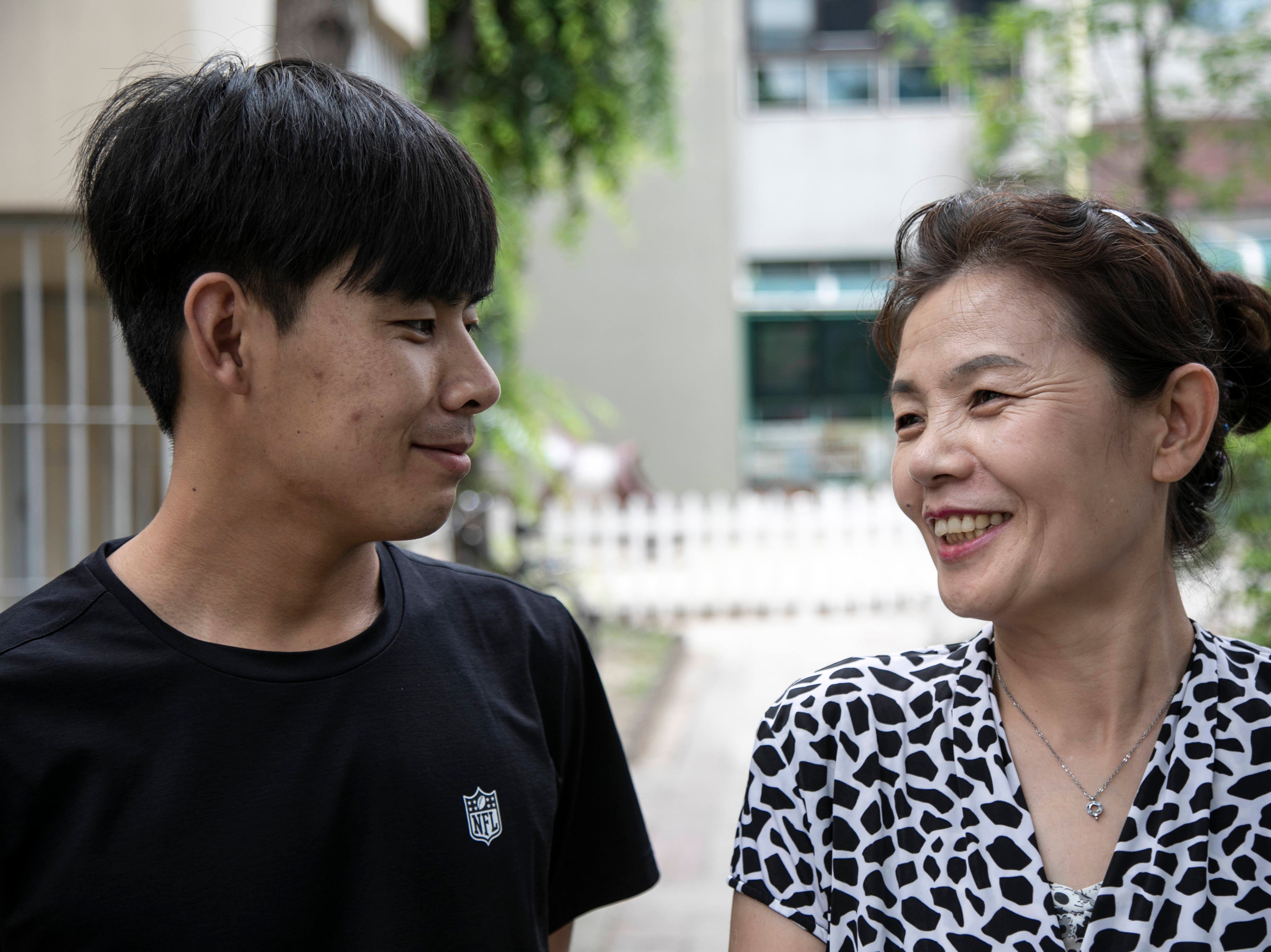 Kim Kang-woo, left, and his mother, Im Su-ryuh, near her apartment in Seoul
