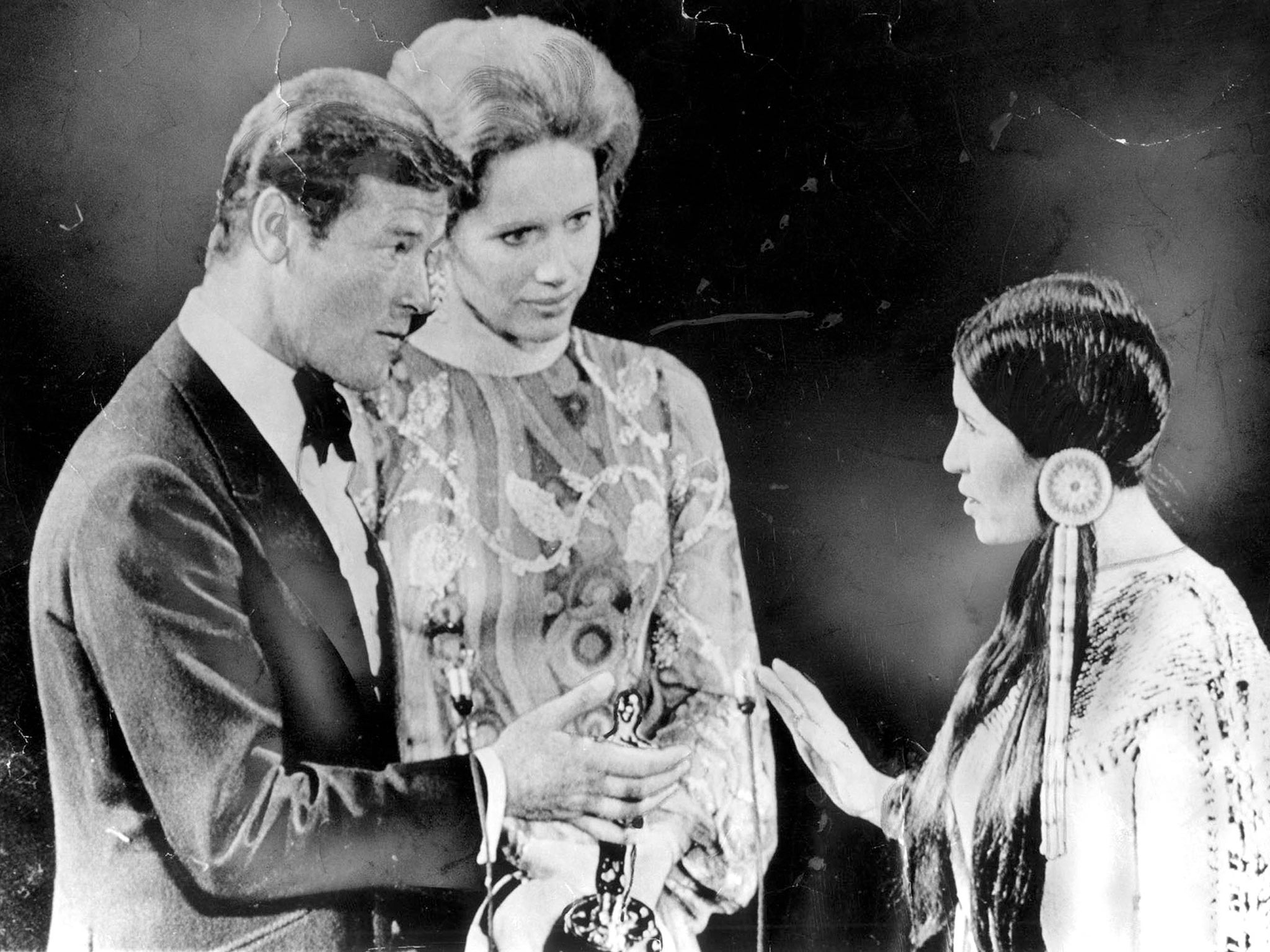 Roger Moore and Liv Ullmann look nonplussed as Sacheen Littlefeather declines the Best Actor Oscar on behalf of Marlon Brando in 1973