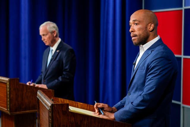 <p>U.S. Sen. Ron Johnson, R-Wis., left, and his Democratic challenger Mandela Barnes wait for start of a televised debate, Friday, Oct. 7, 2022, in Milwaukee</p>