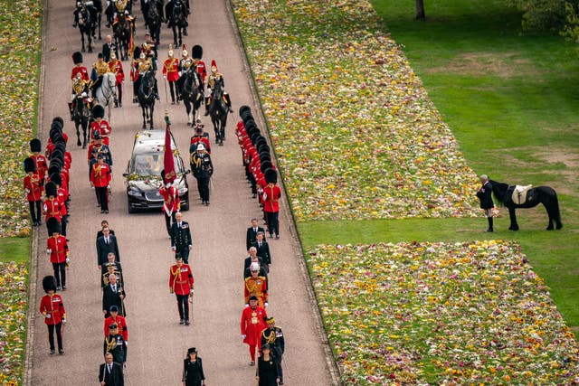 <p>Emma, the monarch’s fell pony, standing besides floral tributes as the Ceremonial Procession of the coffin carrying the Queen arrived at Windsor Castle for her Committal Service at St George’s Chapel (PA)</p>