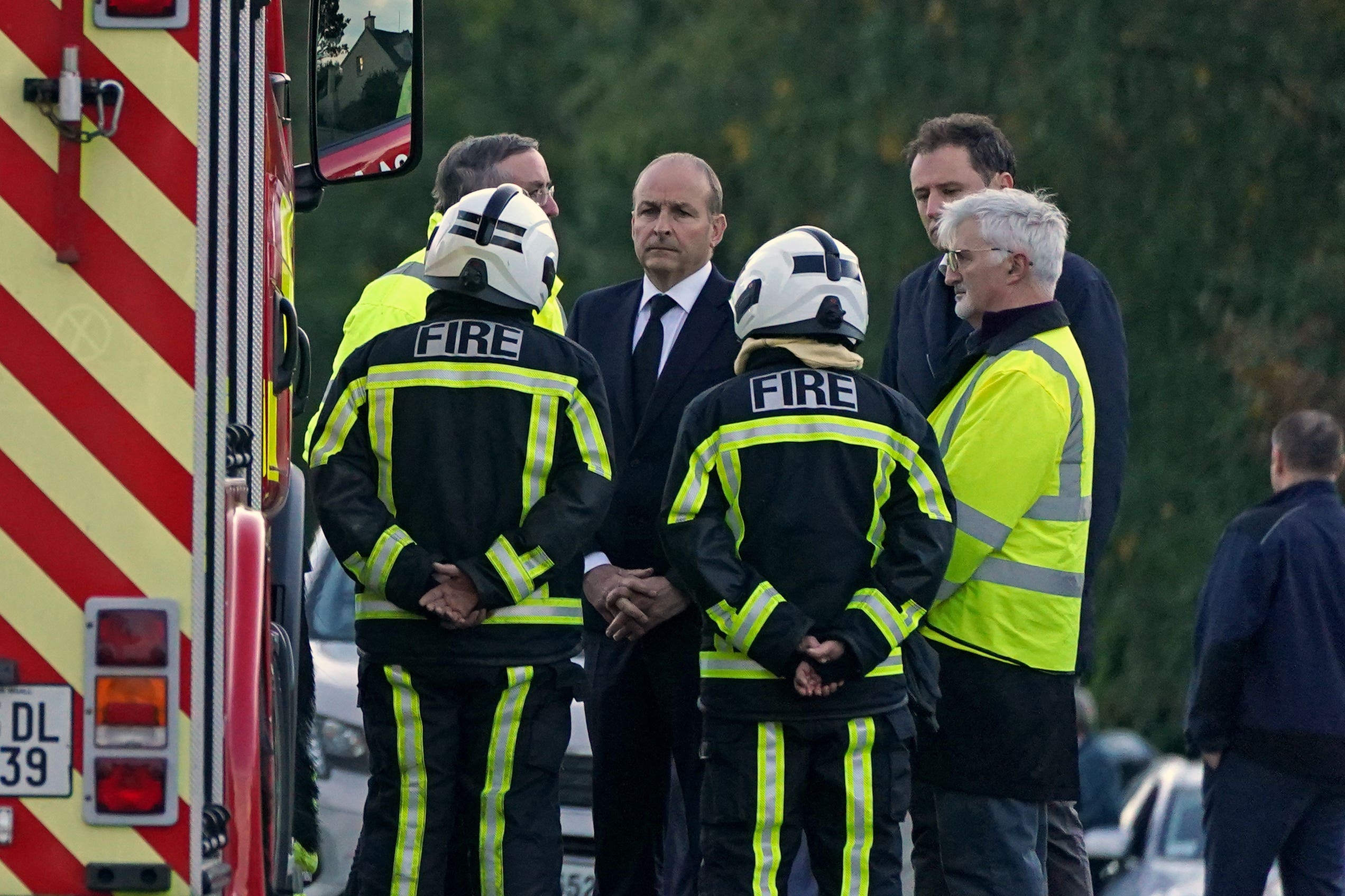 Taoiseach Micheal Martin (centre) speaks with members of the fire service at the scene of an explosion at Applegreen service station in the village of Creeslough in Co Donegal, where ten people have now been confirmed dead. Picture date: Saturday October 8, 2022.