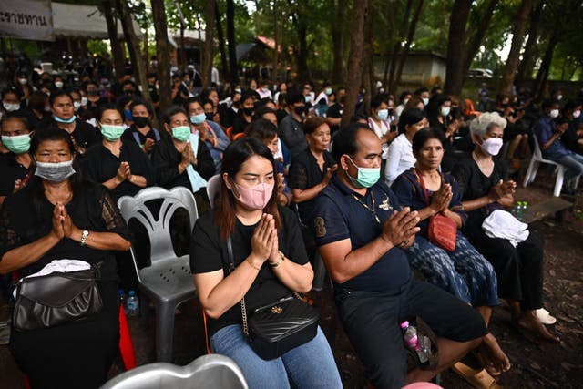 <p>Members of the community take part in Buddhist prayers during the funeral rites for victims of the nursery mass shooting at Wat Si Uthai temple in Thailand on 8 October 2022</p>