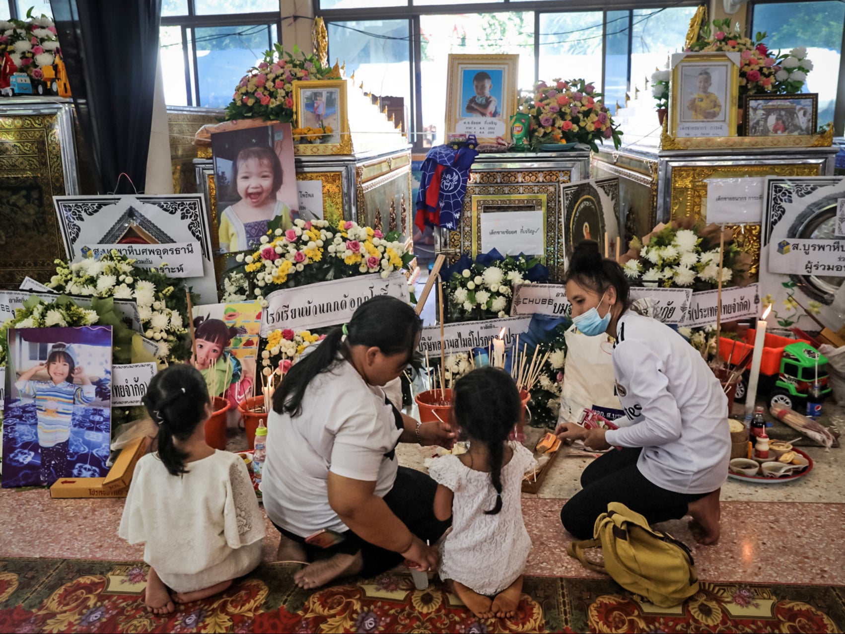 Grieving families mourn through the night in temples after children massacred at Thailand nursery The Independent