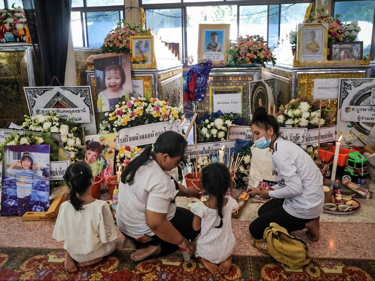 Grieving families mourn through night in temples after 23 children massacred at Thailand nursery