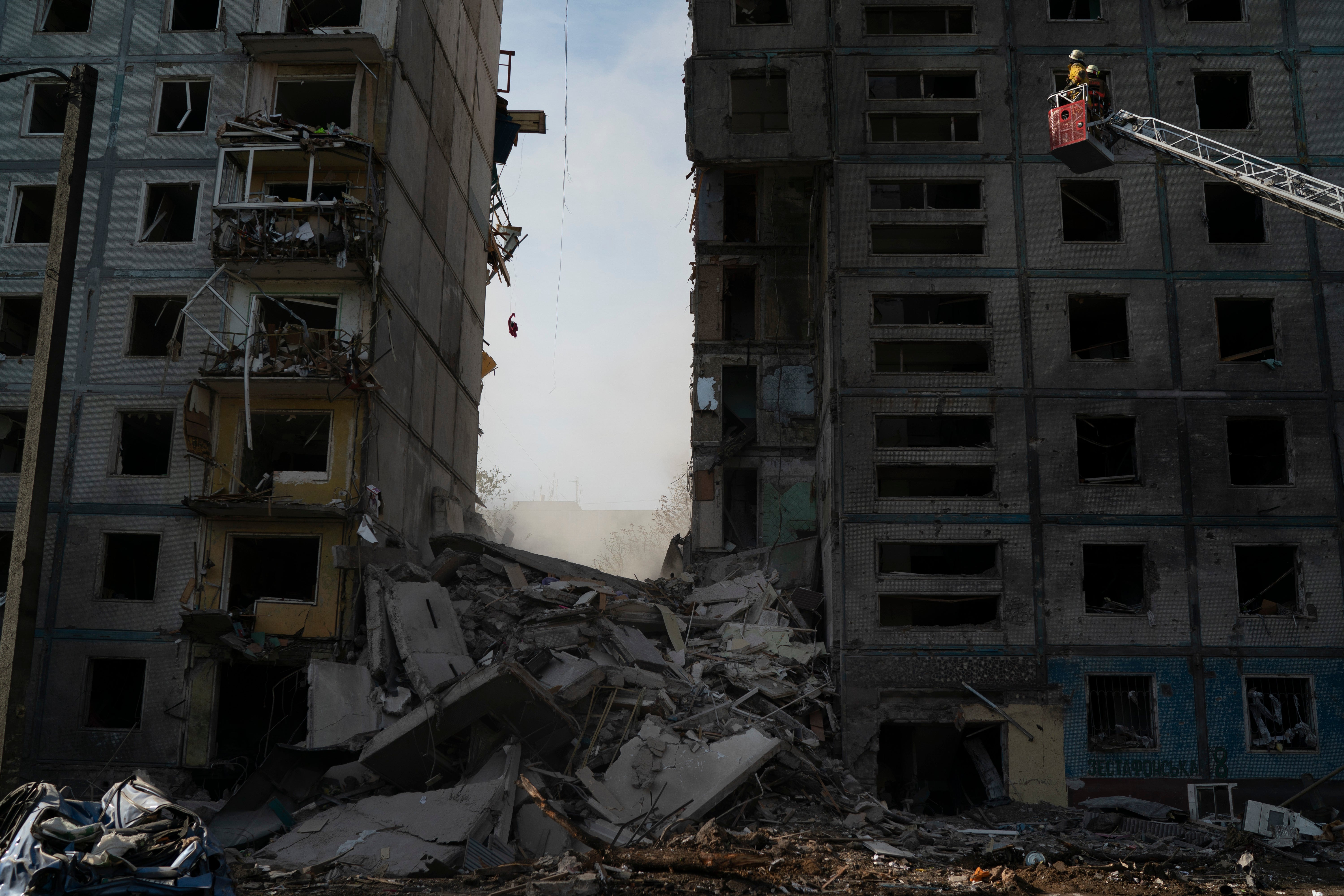 Firefighters respond at a residential building levelled in the blast