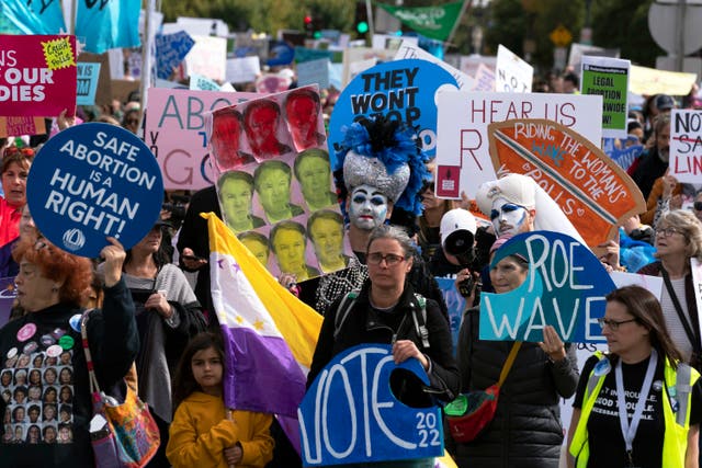 <p>Demonstrators hold signs as they march during the Women’s March in Washington, Saturday, Oct. 8, 2022. </p>