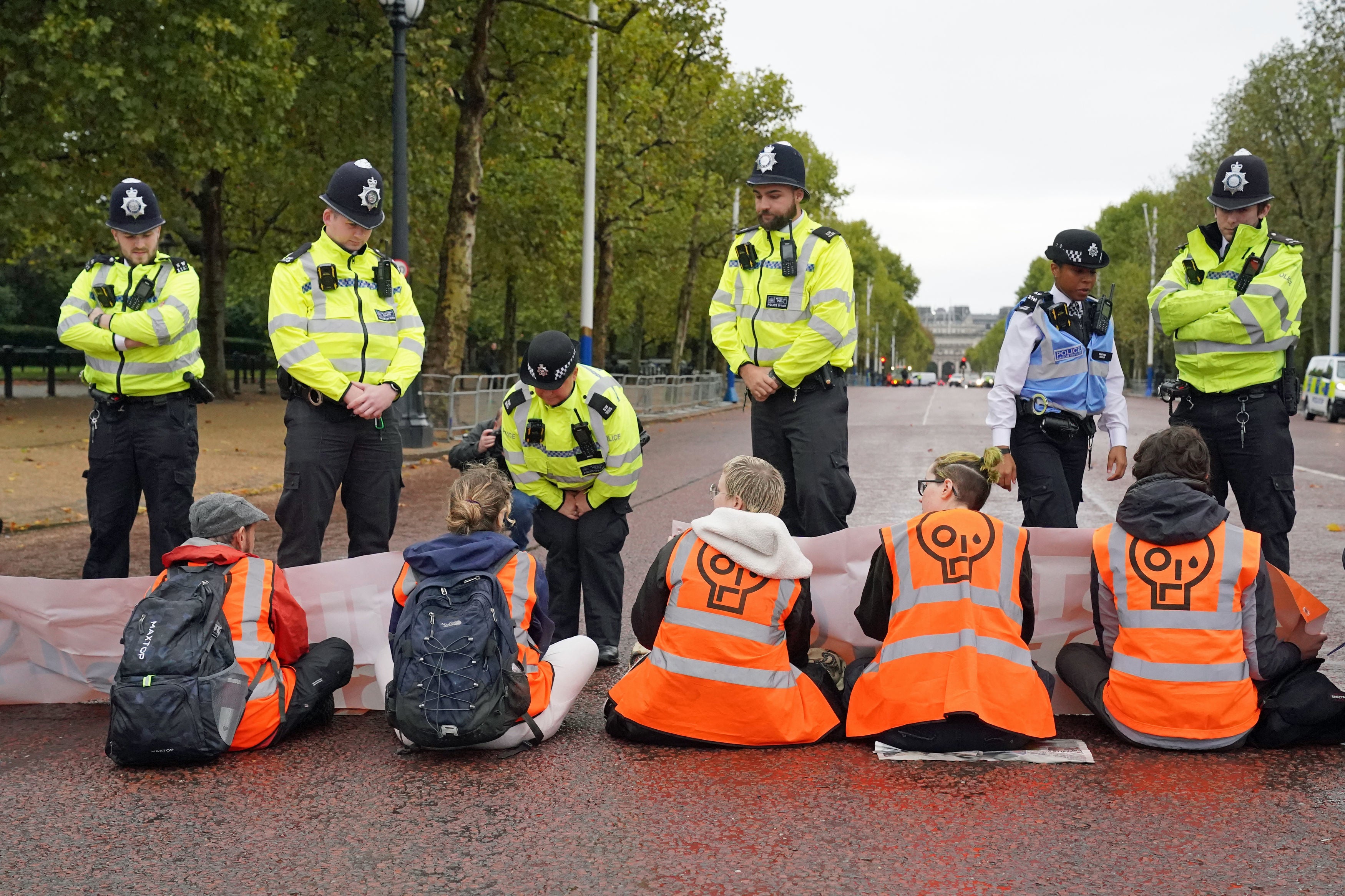 Police speak to campaigners from Just Stop Oil during a protest outside Buckingham Palace