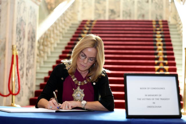 The Lord Mayor of Belfast Tina Black is the first to sign a book on condolence for the victims of the Creeslough tragedy at Belfast City Hall (Belfast City Council/PA)