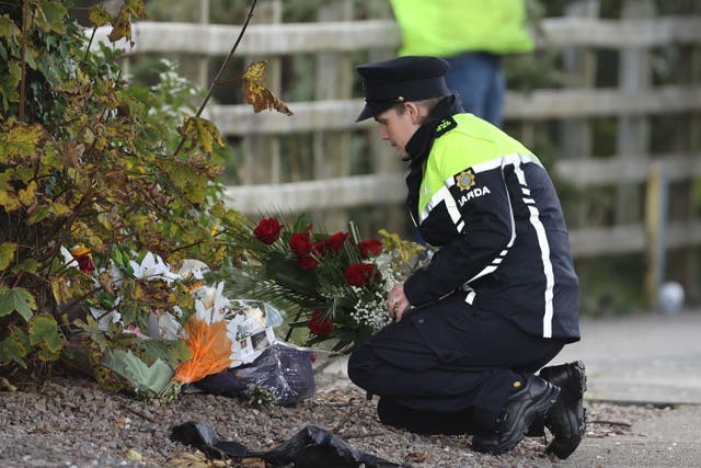 A member of An Garda Siochana lays flowers she was given by a member of the public at the scene of an explosion at Applegreen service station in the village of Creeslough in Co Donegal on Friday where ten people have now been confirmed dead. Picture date: Monday October 10, 2022.