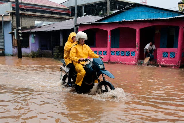 <p>People ride a motorbike through flooded streets in Bluefields, Nicaragua on Sunday</p>