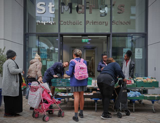 <p>Parents queue for food outside St Mary’s RC Primary School in Battersea, south London </p>