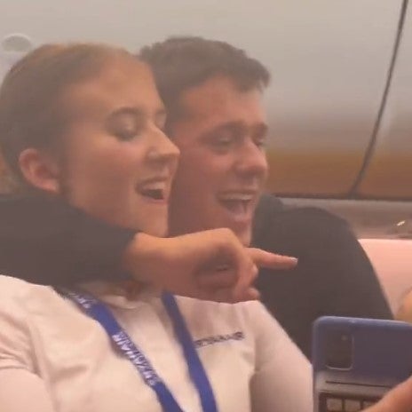 One member of the group grabs a flight attendant for a selfie
