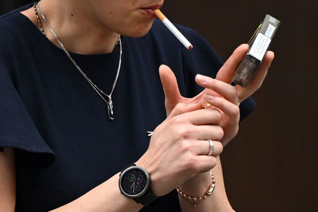 <p>A woman is seen smoking a cigarette in central London on June 9, 2022</p>