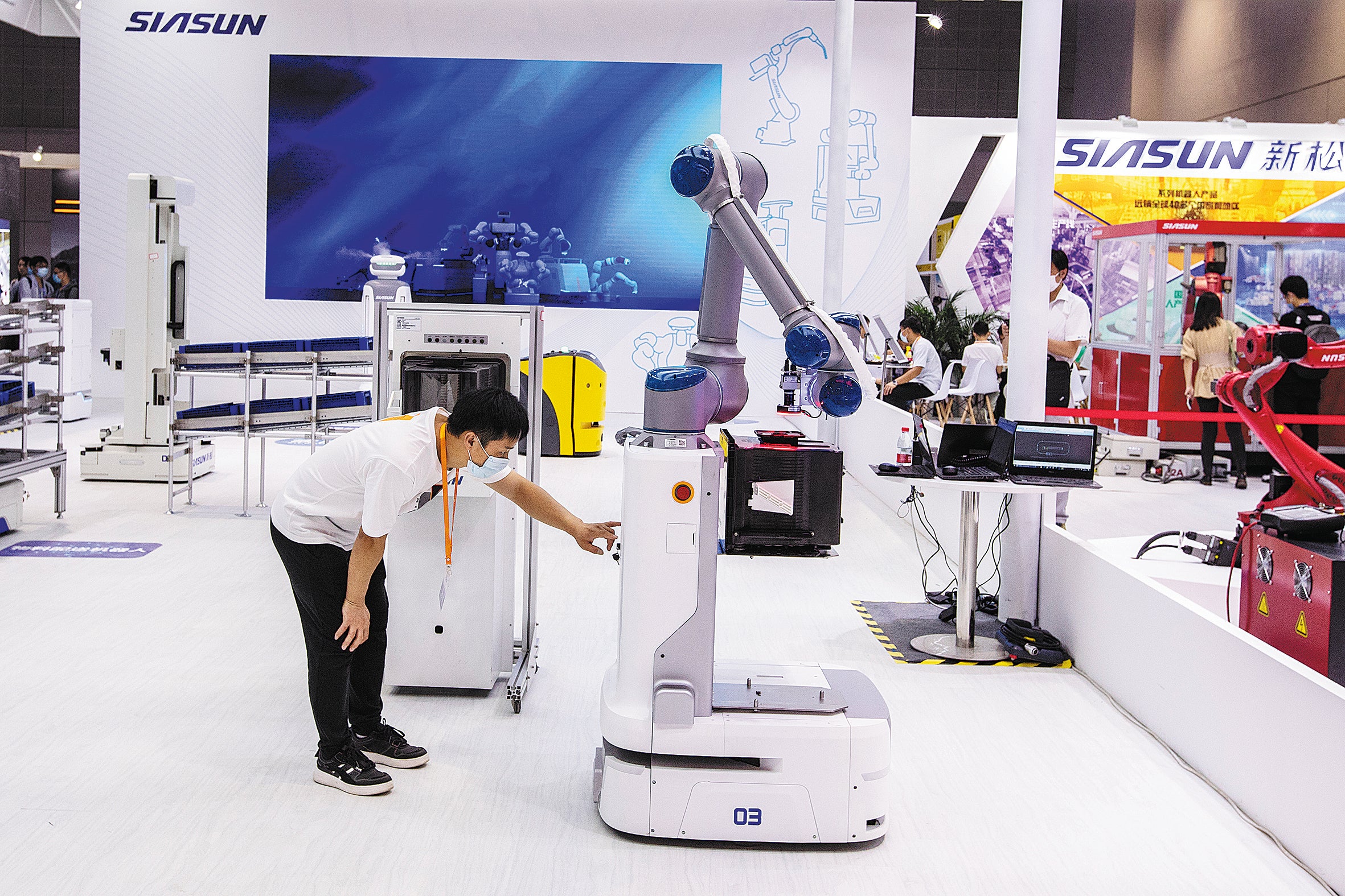 A visitor inspects an industrial robot at the booth of Siasun Robot & Automation Co during an industry expo in Shanghai in September 2020.
