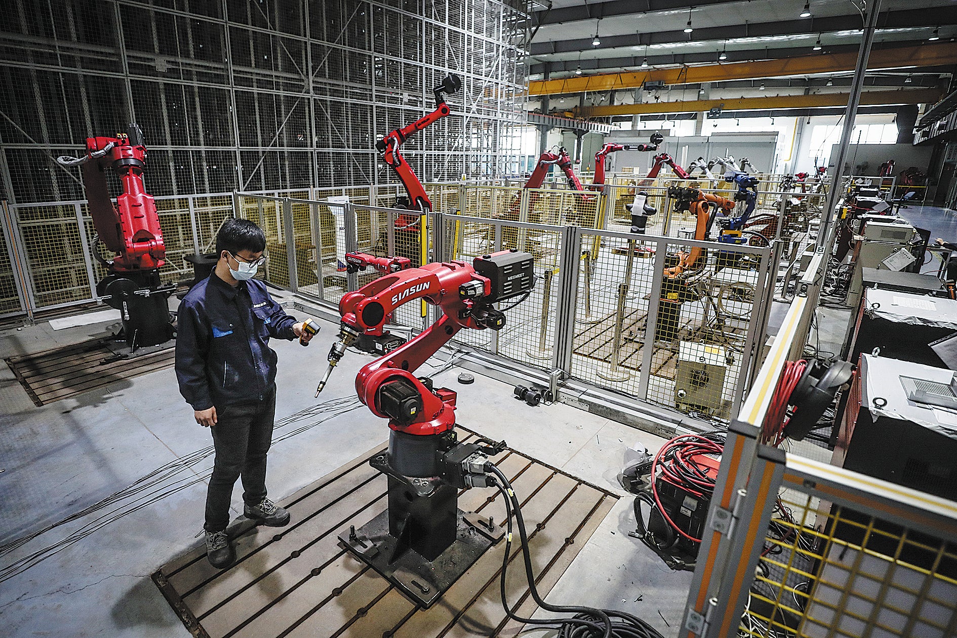 A Siasun technician inspects robots at a workshop in Shenyang, Liaoning province, in April 2022